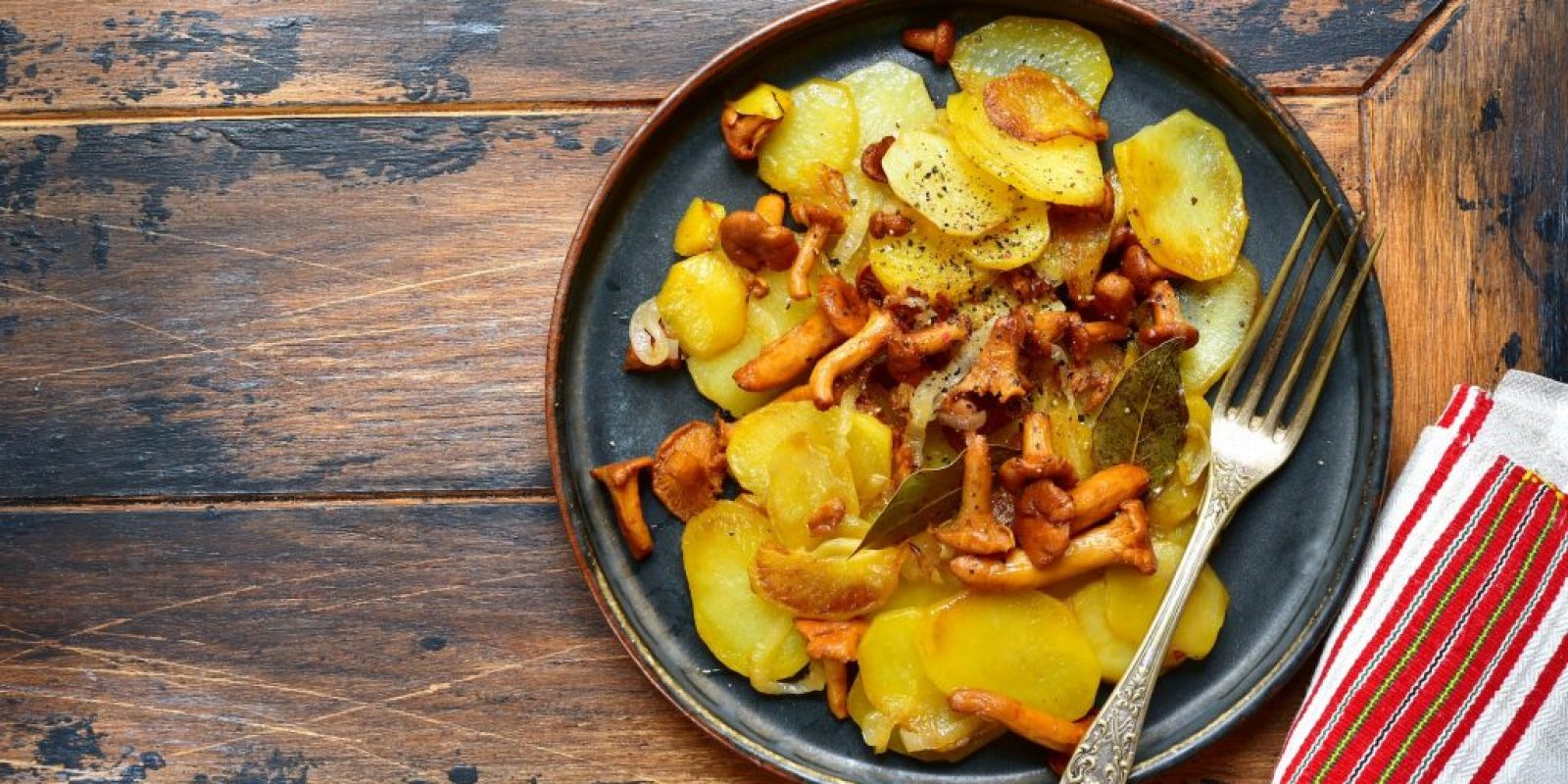 Mit Pfifferlingen und Zwiebeln gebratene Kartoffelscheiben